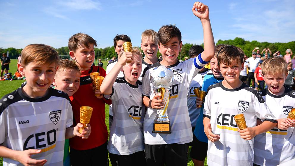 Junior boys footballers, from the same team, celebrating winning trophies at LAOLA cup.