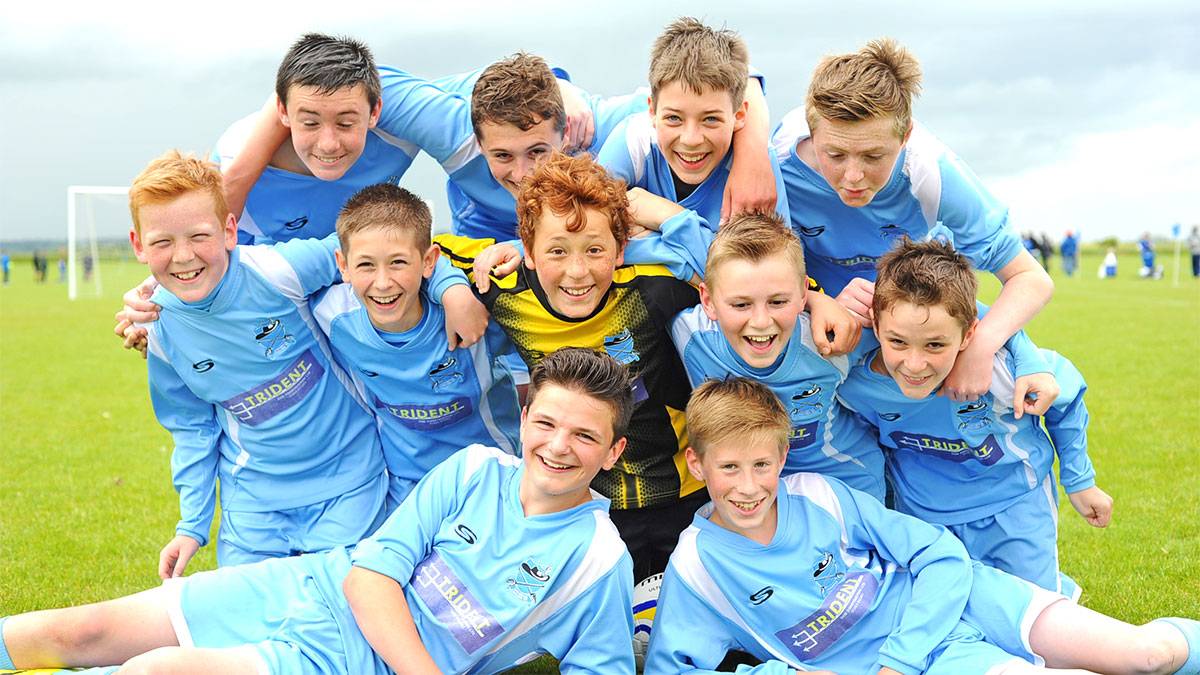 Junior boys football team pose for the camera.