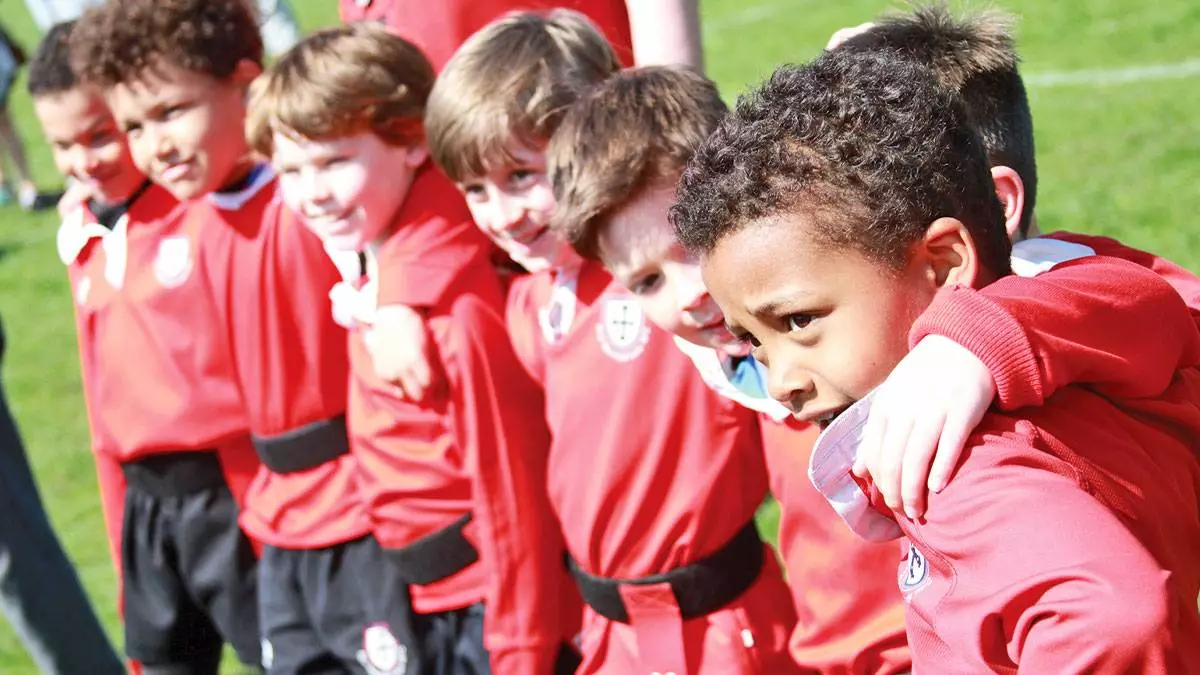 Boys rugby team smile and look at something off camera.