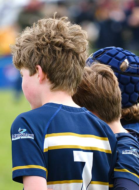 Two rugby players watch on