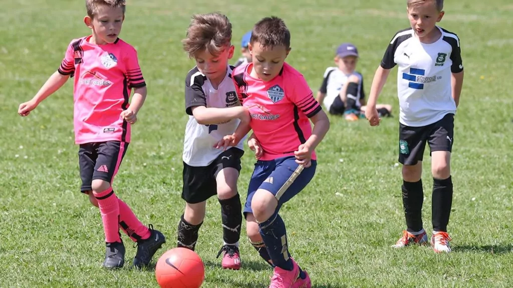 Four players, two from each side, compete for the ball