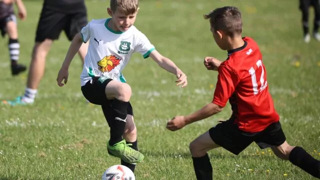 Two boys players go for the football