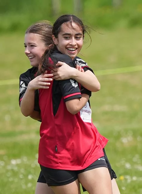 Girl football players hug after celebrating