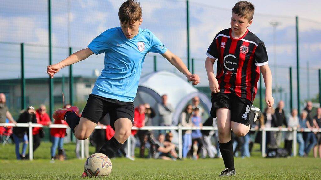 Two players chase and compete for the football