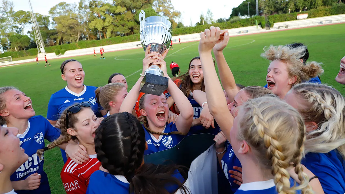 A grassroots team celebrate with the tournaments trophy held high.