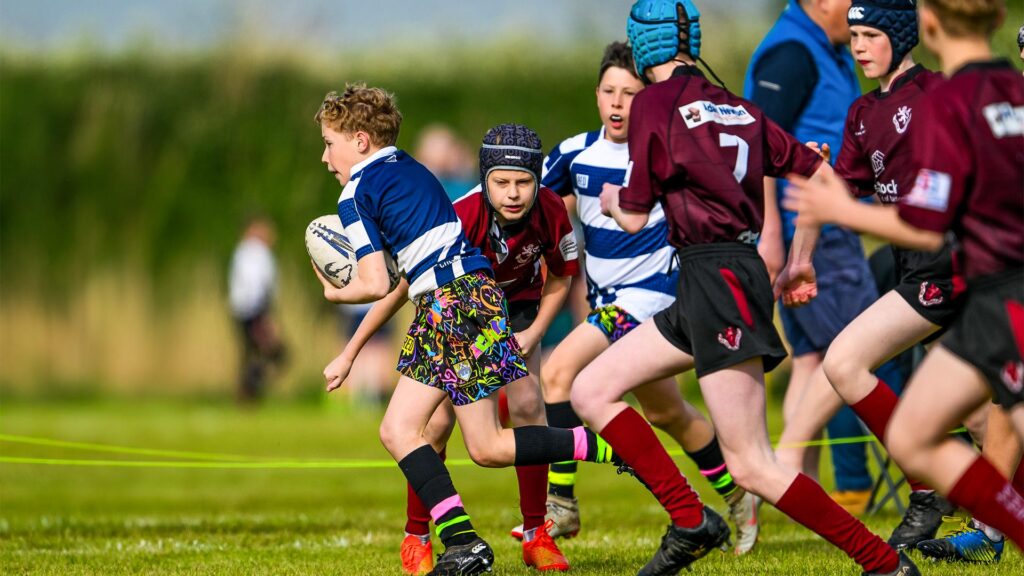A young rugby player has just broke through the opposition and is headed towards the goal area
