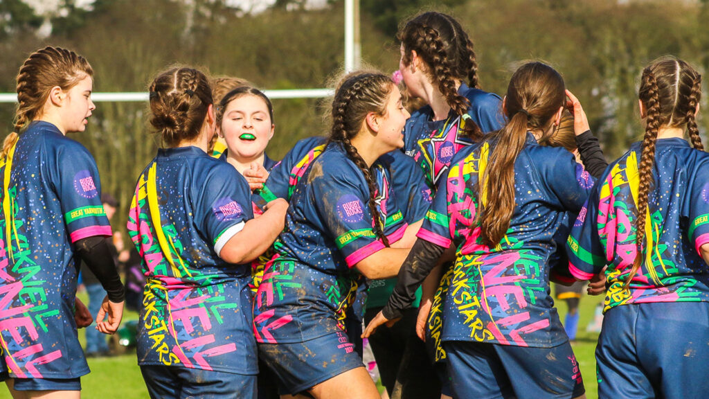 Girls rugby players celebrating after playing a match