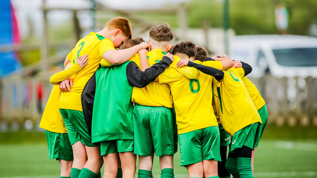 A young football group huddle to discuss tactics