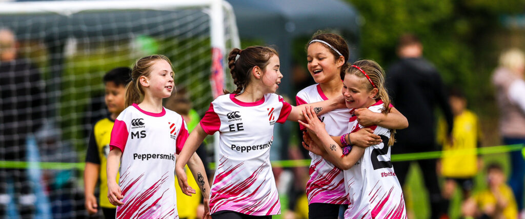 Girl footballer players celebrating after a goal