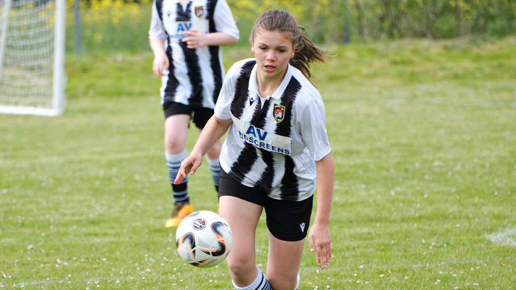 A young female footballer gets ready to take possession of the ball
