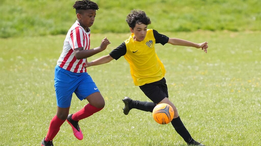 Two youth football players getting ready to receive the ball
