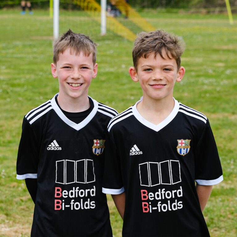 Two youth football players posing for a photo together