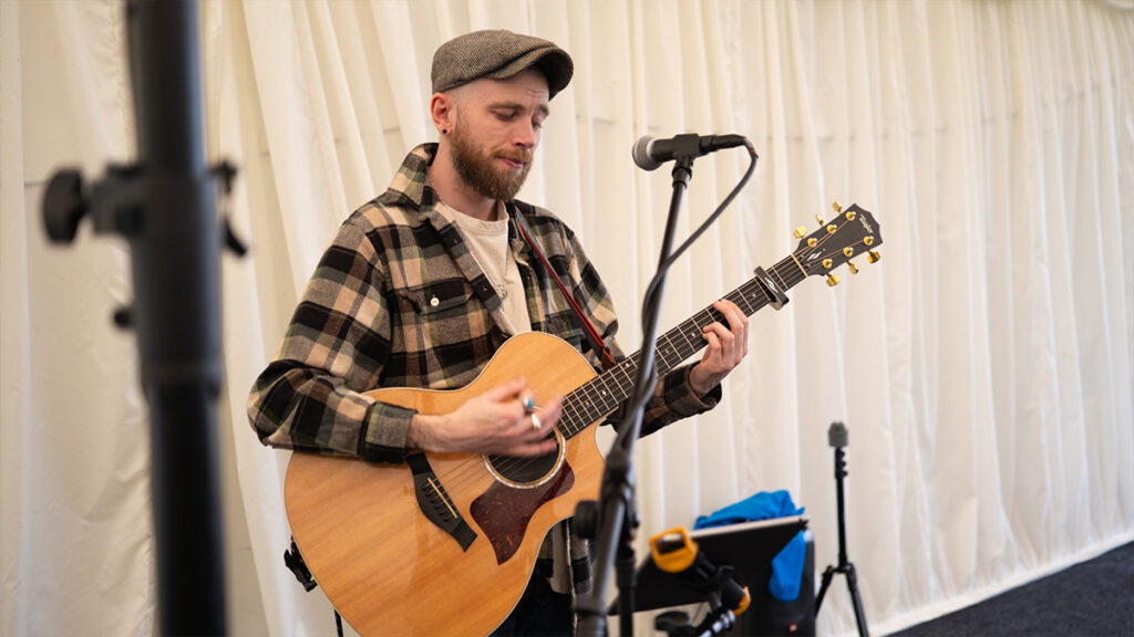 A young singing guitar player performing at Heidelberg Materials fun day