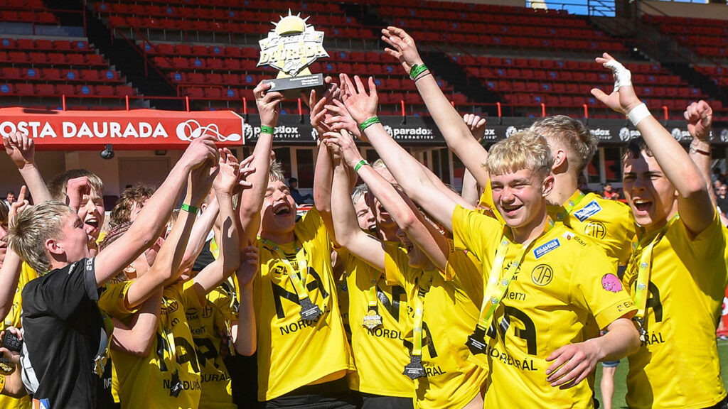A youth team celebrating their win with a trophy at the Costa Daurada Football Cup