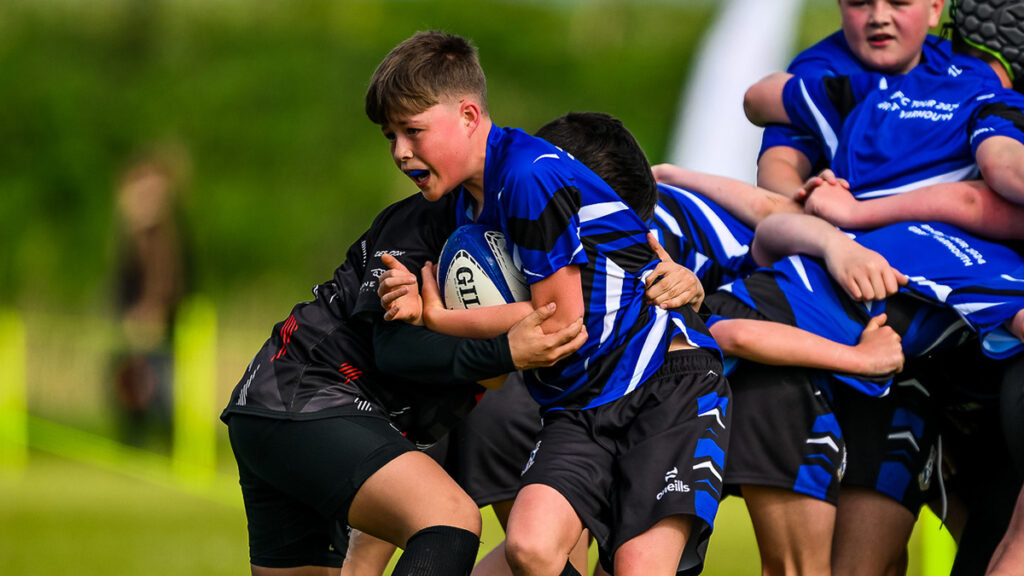 Young rugby player tackles another player for the ball