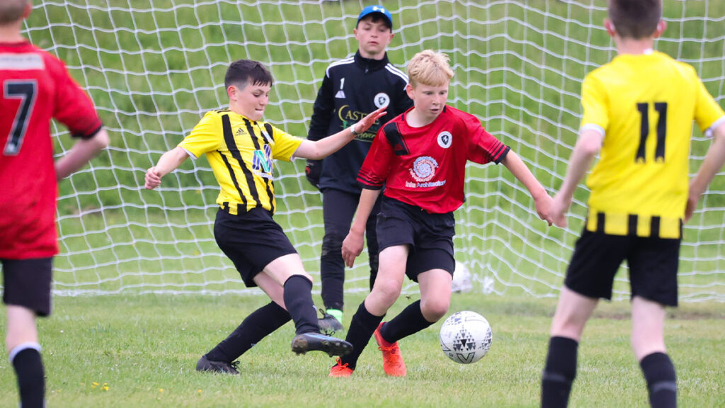 Two youth football teams challenging for the ball