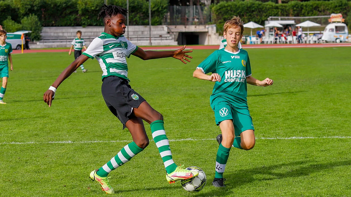 Two young footballers challenging for possession of the ball in a football game