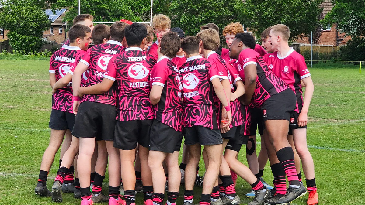 A young team of rugby players huddling to discuss tactics before a match