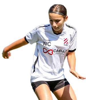 Young girl football player dribbling the ball up field