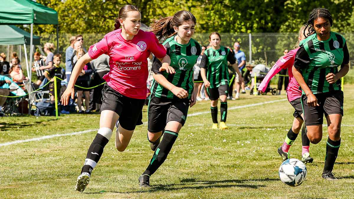 Two young girls football teams competing at a UK Tournament