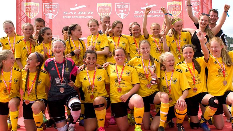 A girls team celebrating on stage at the Barcelona Girl Cup