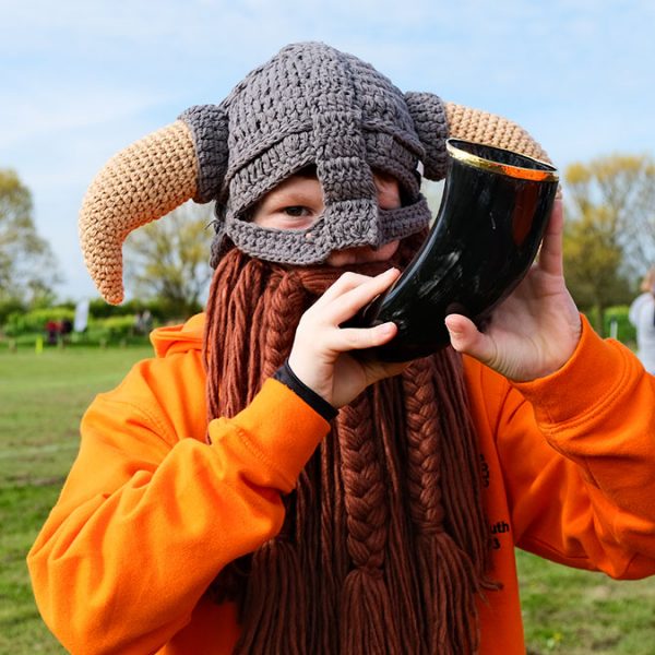 A young rugby player with a knitted viking hat and horn
