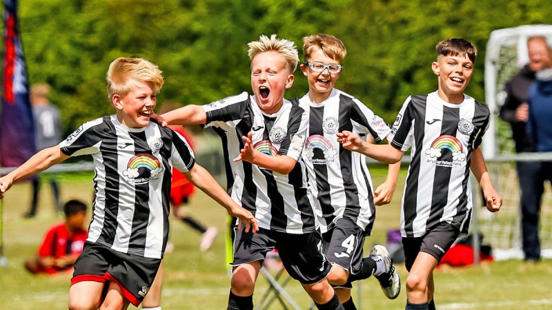 A young football team celebrating after scoring a goal