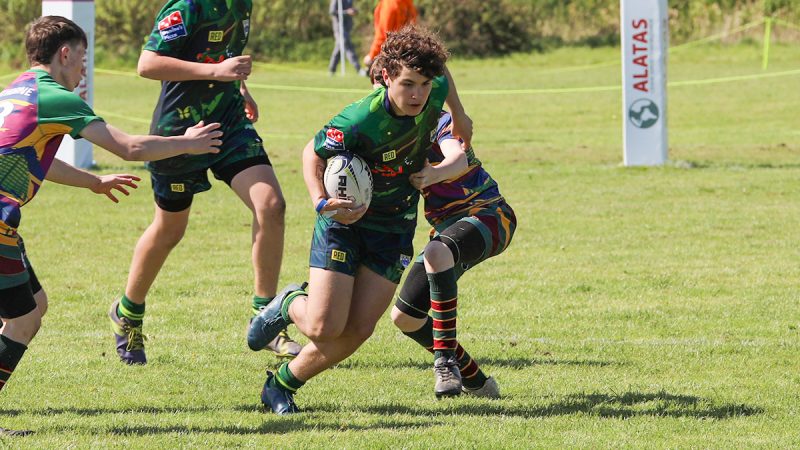 A young rugby player slips past the defence to push up field