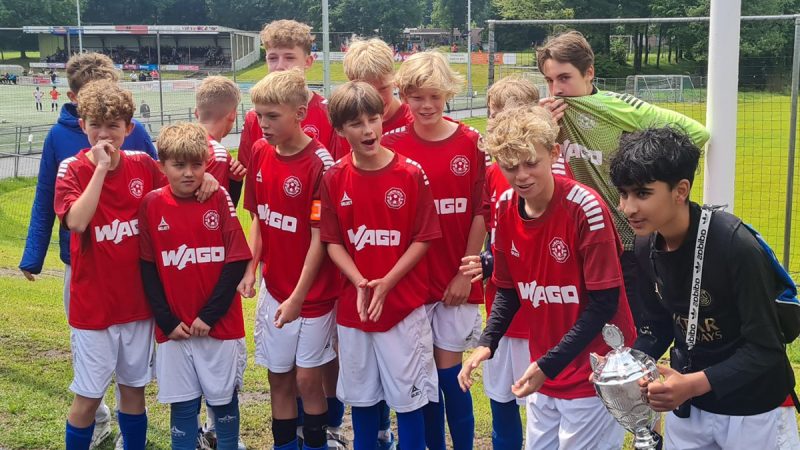 A young football team celebrating with a photo after playing at the Roermond Cup